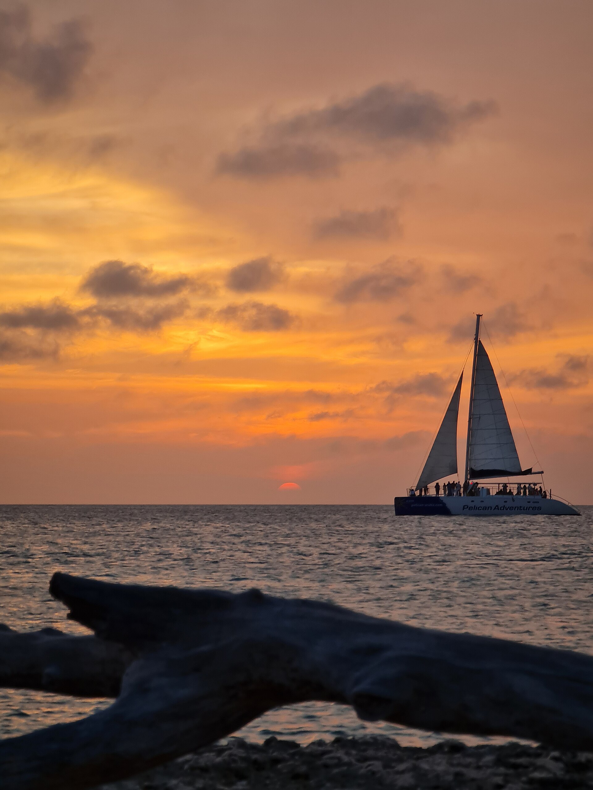 Katamaraan päikeseloojangul troopilises ookeanis — sarnane Bali sunset cruise kogemusega.
