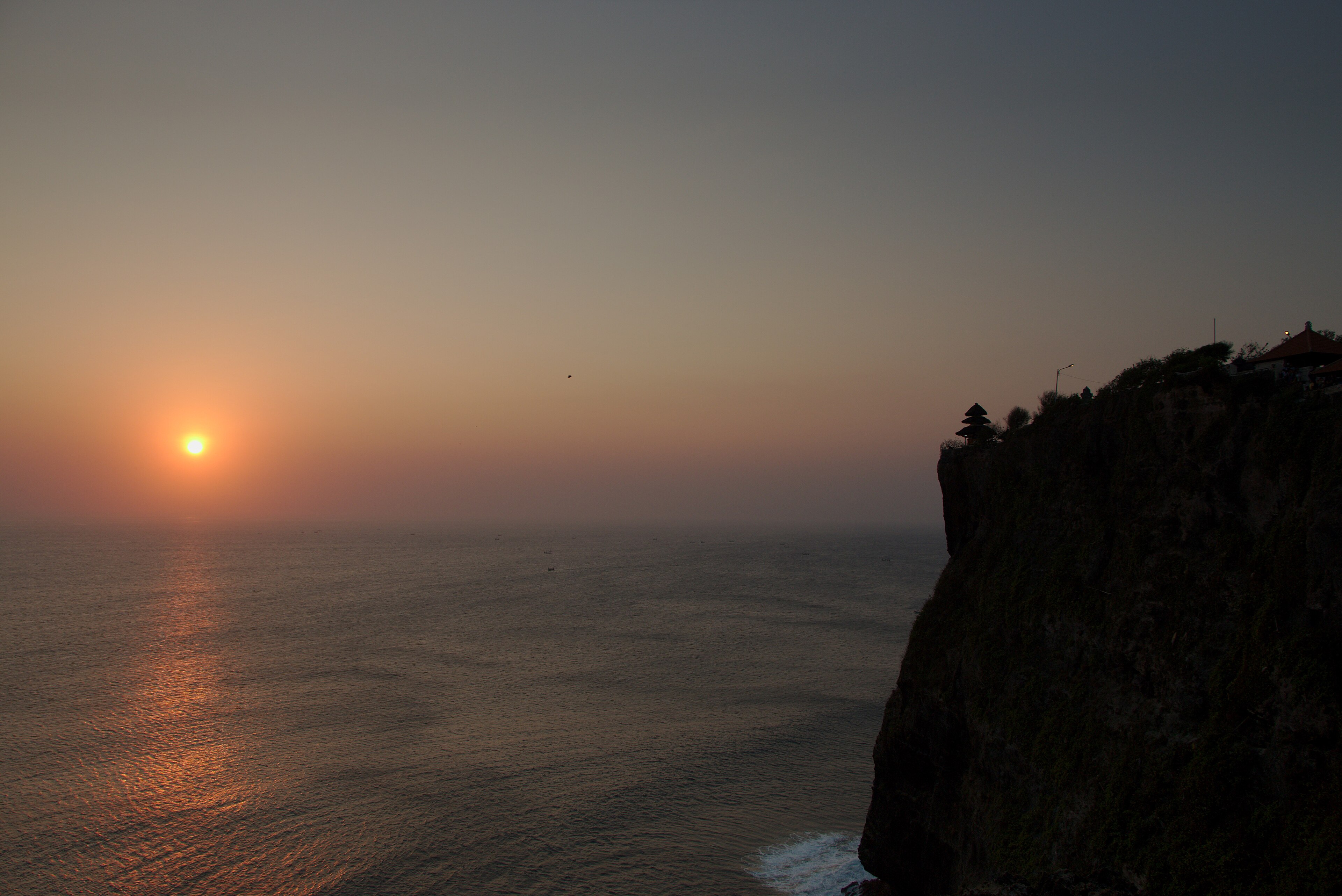 Uluwatu tempel kalju serval päikeseloojangul — saun ja külmavanniring asuvad samas servas.
